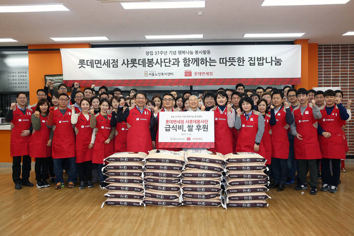 장선욱 롯데면세점 대표이사와 샤롯데봉사단 임직원 60여명이 창립 37주년을 맞아 종로구 서울노인복지센터에서 급식 후원금과 쌀을 전달하고 기념 사진을 촬영하고 있다. 맨 앞줄 왼쪽부터 최병록 롯데면세점 지원부문장, 장선욱 롯데면세점 대표이사, 희유 스님 서울노인복지센터 관장, 김금주 롯데면세점 노조위원장, 김점숙 롯데면세점 노조사무국장. (사진=롯데면세점) 