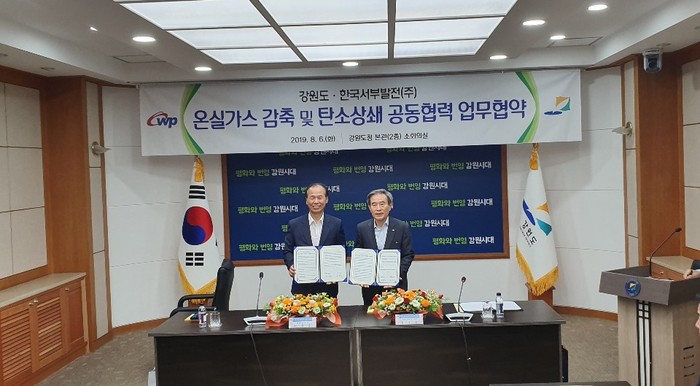 김병숙 한국서부발전 김병숙 사장(오른쪽)과 최문순 강원도 도지사가 ‘온실가스 감축 및 탄소상쇄 공동협력 업무협약’을 체결하고 기념 촬영을 하고 있다.<사진=한국서부발전> 