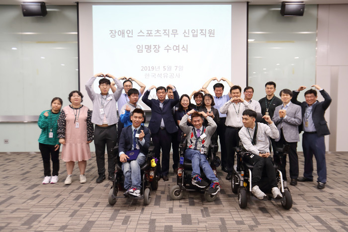지난 5월 한국석유공사 스포츠직무 부문에 신규 입사한 장애인들이 관계자와 기념 촬영을 하고 있다.<사진=한국석유공사> 