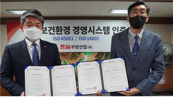 조유선 SM우방산업 대표(왼쪽)가 23일 안전보건경영시스템(ISO 45001)과 환경경영시스템(ISO 14001)인증서를 받고 기념촬영을 하고 있다. <사진제공=SM그룹>