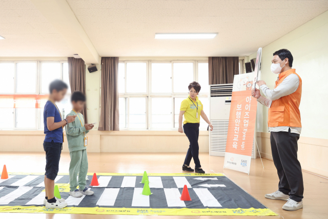 한화손해보험 봉사단이 15일 오전 서울 용산구 소재의 보광초등학교를 방문해 5학년 학생들을 대상으로 ‘아이즈업(Eyes up) 보행안전교육’을 진행했다. <사진=한화손해보험>