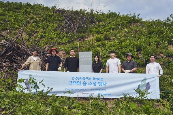 지난 5월 경북 울진군에서 한국투자증권이 고객의 숲 조성 행사를 열고 관계자들과 기념사진을 촬영하고 있다. <사진=한국투자증권>