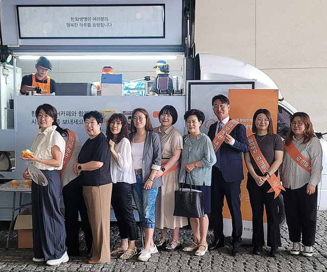 23일 오전 한화생명금융서비스 이재선 남수원지역단장(오른쪽 세번째)이 한화생명 ‘H카페-Summer’ 이벤트를 통해 FP들과 간식을 나눈 뒤 기념 촬영을 하고 있다. <사진=한화생명>
